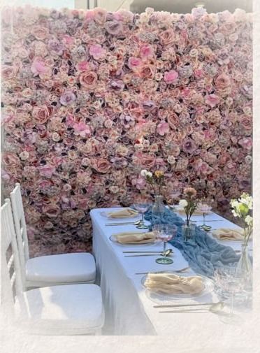 Blush flower wall with styled table and Chiavari chairs
